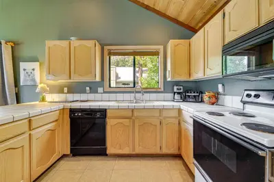 a kitchen with wooden cabinets and a black dishwasher at Close to Ski Slopes Tahoe Ski Chalet with Fireplace in Tahoe City