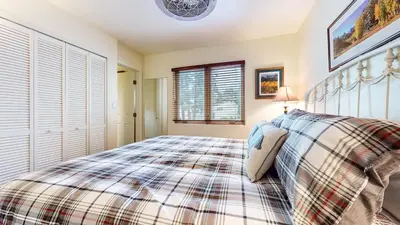 a bedroom with a bed with a plaid blanket at Lakeview Villas #26 condo in Mammoth Lakes