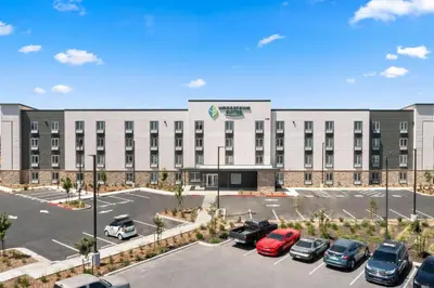 an image of a hotel with cars parked in a parking lot at WoodSpring Suites Ceres - Modesto in Ceres