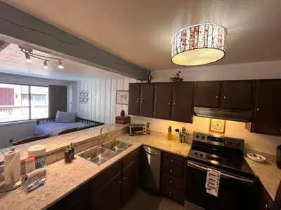 a kitchen with a sink and a kitchen with a bed at Walk-to-Lifts Condo with Hot Tub, Dog Friendly in Mammoth Lakes