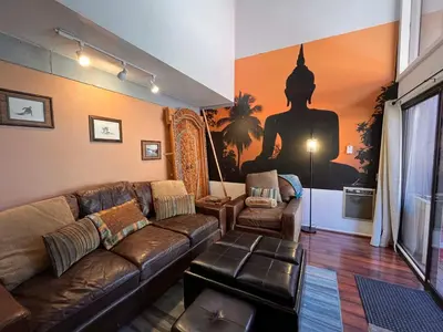 a living room with a brown couch and a large mural at Walk-to-Lifts Condo with Hot Tub, Dog Friendly in Mammoth Lakes