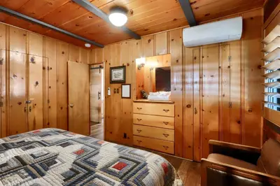 a bedroom with wooden walls and a bed in a room at 45 The Overlook in Wawona