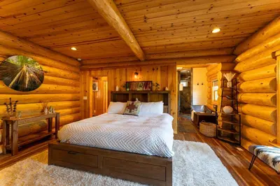 a bedroom with a bed in a log cabin at Peppermint Falls Ranch in Ponderosa