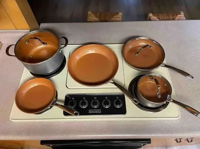 three pots and pans on a stove top at Cozy Chalet - Hot Tub with Meadow Views - Family & Pets, Fire Pit & BBQ in Arnold