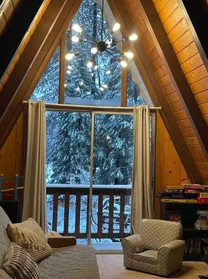 a living room with a large window in a cabin at Cozy Chalet - Hot Tub with Meadow Views - Family & Pets, Fire Pit & BBQ in Arnold