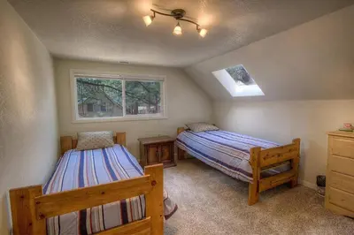 a bedroom with two beds and two windows at Corner Pocket Chalet home in South Lake Tahoe