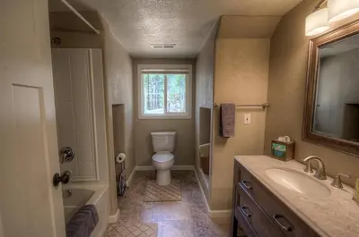 a bathroom with a toilet and a sink and a window at Corner Pocket Chalet home in South Lake Tahoe