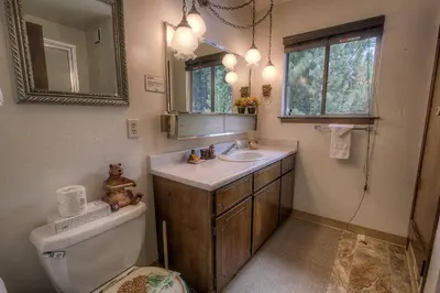 a bathroom with a sink and a toilet and a mirror at Bambi's Bunkhouse home in South Lake Tahoe