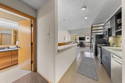 a kitchen with a door leading to a dining room at Palisades Tahoe Lodge Rentals Studio Loft #356 in Olympic Valley