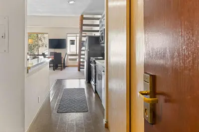 a kitchen with a door leading to a living room at Palisades Tahoe Lodge Rentals Studio Loft #356 in Olympic Valley