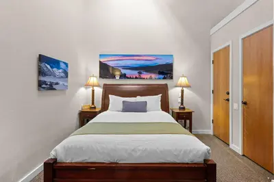 a bedroom with a large bed with two lamps on two tables at Palisades Tahoe Lodge Rentals Premium Studio Loft #336 in Olympic Valley