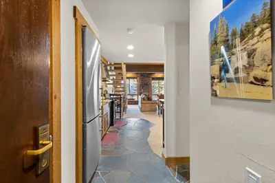 a hallway with a door leading to a living room at Palisades Tahoe Lodge Rentals Studio Loft #344 in Olympic Valley