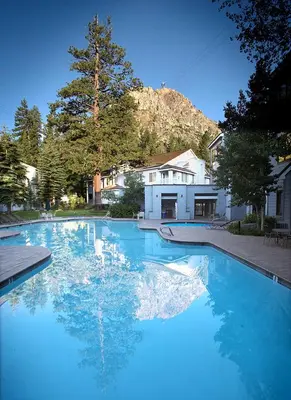 a large pool of blue water in front of a house at Palisades Tahoe Lodge Rentals Studio Loft #344 in Olympic Valley