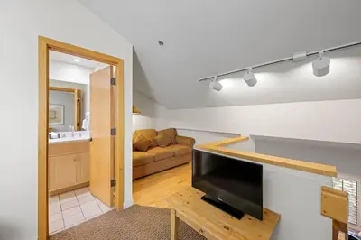 a living room with a large flat screen tv at Palisades Tahoe Lodge Rentals Studio Loft #346 in Olympic Valley