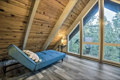 a living room with a blue couch and large windows at Tahoe Time Cabin in Incline Village