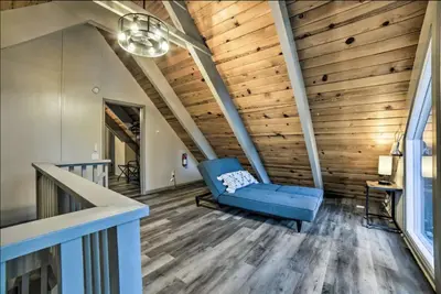 a living room with a blue couch and wooden ceilings at Tahoe Time Cabin in Incline Village