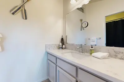 a bathroom with a sink and a large mirror at Above the Green in Groveland