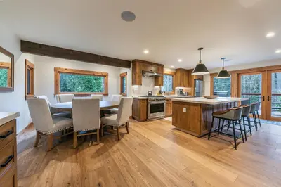 a kitchen and dining room with a table and chairs at Eclipse Retreat at Tahoe Park - Hot Tub - Fenced Yard & steps to HOA Access in Tahoe City
