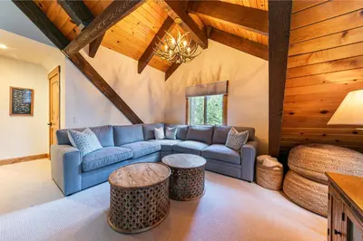 a living room with a blue couch and a table at Eclipse Retreat at Tahoe Park - Hot Tub - Fenced Yard & steps to HOA Access in Tahoe City
