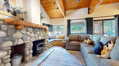 a living room with a couch and a stone fireplace at Bigwood #45 condo in Mammoth Lakes