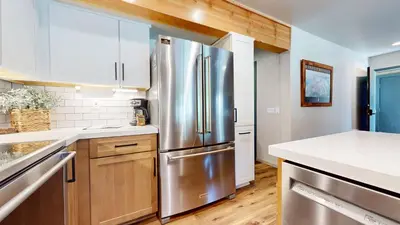a kitchen with a stainless steel refrigerator and wooden cabinets at Bigwood #45 condo in Mammoth Lakes