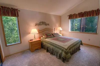 a bedroom with a bed and two windows at Aspen View Lodge home in South Lake Tahoe