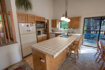 a kitchen with a refrigerator and a table with chairs at Aspen View Lodge home in South Lake Tahoe