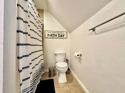 a bathroom with a toilet and a sign that reads faith day at Cabin in the Trees-Game Room in Pollock Pines
