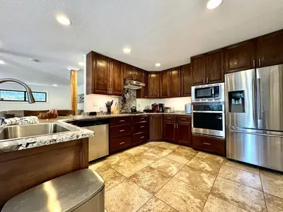 a kitchen with wooden cabinets and stainless steel appliances at Cabin in the Trees-Game Room in Pollock Pines