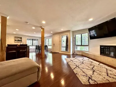 a large living room with a couch and a kitchen at Cabin in the Trees-Game Room in Pollock Pines