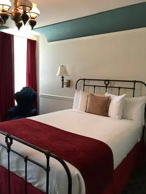a bedroom with a bed with a red blanket at Mizpah Hotel in Tonopah