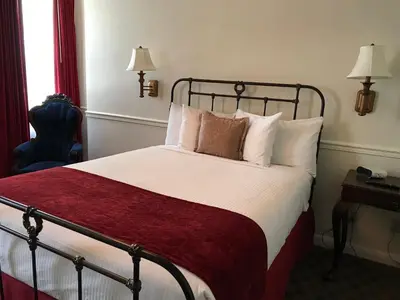 a hotel room with a bed with a red blanket at Mizpah Hotel in Tonopah