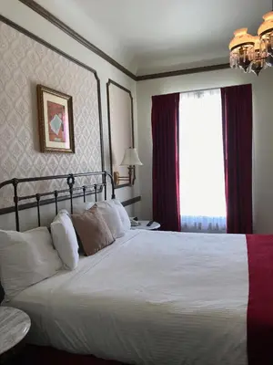 a bedroom with a large white bed and a window at Mizpah Hotel in Tonopah