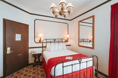 a hotel room with a bed and a mirror at Mizpah Hotel in Tonopah