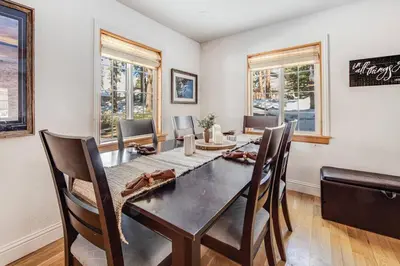 a dining room with a table and chairs and windows at Alpine Cottage Hideaway in Stateline