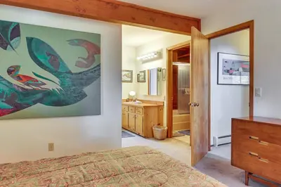 a bedroom with a bed and a bathroom at 1 Mi to Beach Peaceful Tahoe Vista Home with Decks! in Tahoe Vista