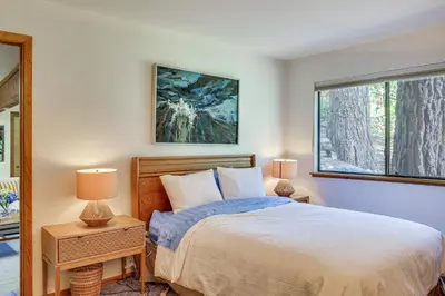 a bedroom with a bed and two lamps and a window at 1 Mi to Beach Peaceful Tahoe Vista Home with Decks! in Tahoe Vista