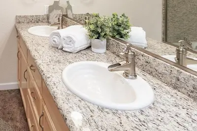 a bathroom counter with two sinks and a mirror at Cabin at the Creek Family Fun Starts Here! in Shaver Lake