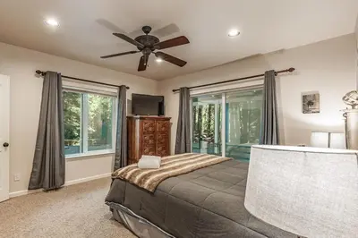 a bedroom with a bed and a ceiling fan at Cabin at the Creek Family Fun Starts Here! in Shaver Lake
