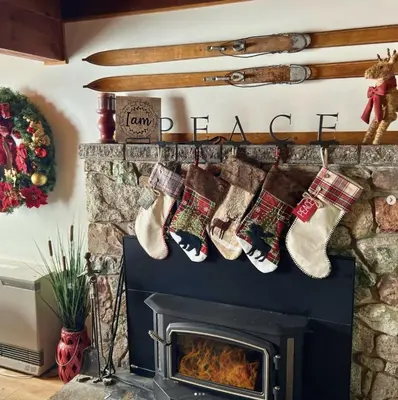 a row of christmas socks hanging over a fireplace at Buckeye Bear's Den-AC-Walking Distance to town in Shaver Lake