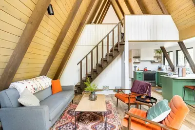 a living room with a couch and a table at Dogwood Peak Mid-Century A-Frame with AC Style in Shaver Lake