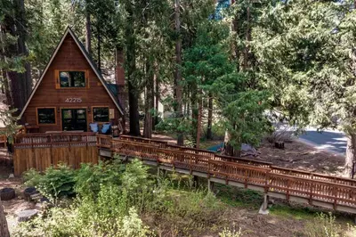 a cabin in the woods with a bridge at HB Hideaway Boho Treehouse Vibes in the Pines in Shaver Lake