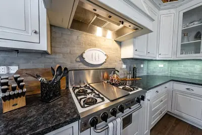 a kitchen with white cabinets and a stove top oven at The Great Escape Sunsets Hot Tub Bliss in Shaver Lake