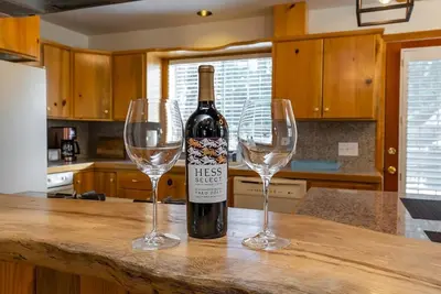 a bottle of wine and two wine glasses on a counter at The Knotty Sparrow Prime Spot Smores Nights in Shaver Lake