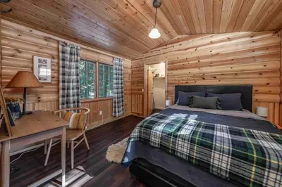a log cabin bedroom with a bed and a desk at The Cedar House Prime Spot Kayaks & Cool AC in Shaver Lake