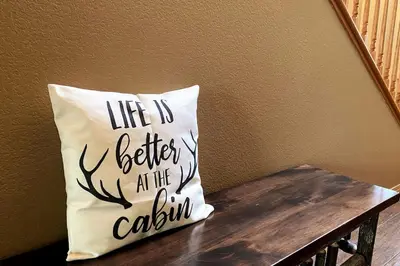 a pillow that says life is better at the cabinilla at Shady Pines Smores, Stars & Cozy Nights In in Shaver Lake