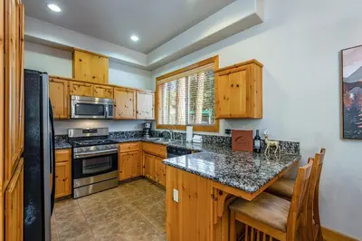 a kitchen with wooden cabinets and a counter top at Sierra Pines Villa Deck Jetted Tub Game Rm in Shaver Lake