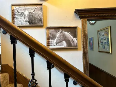 a staircase with two pictures of a horse and a mirror at Lux Western Cabin Pool Table Ping Pong Vibes in Shaver Lake