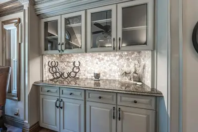 a kitchen with white cabinets and a marble counter top at Lux Western Cabin Pool Table Ping Pong Vibes in Shaver Lake