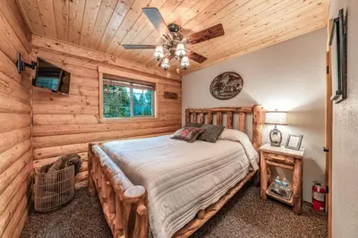 a bedroom with a bed and a ceiling fan at The Stew Cabin Cozy Escape Fireside Memories in Shaver Lake